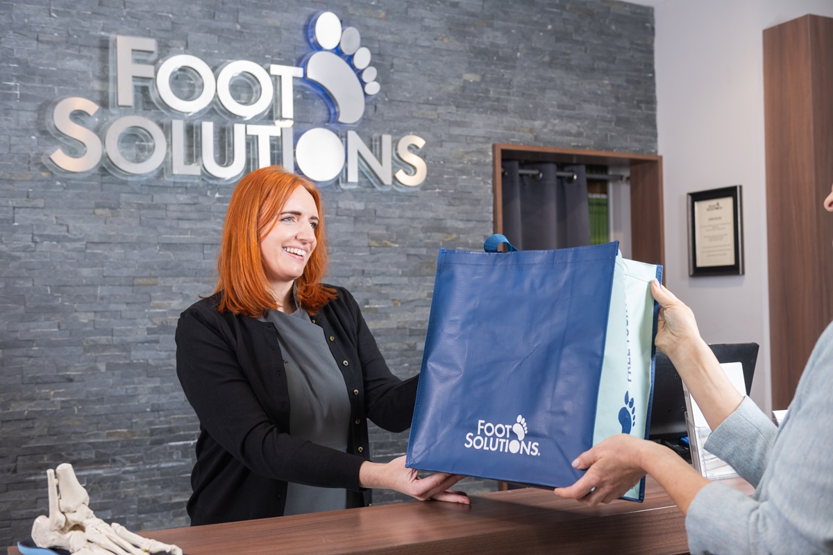 Footsolutions shop assistent serving customer